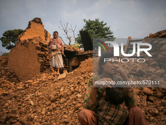 a woman is standing in front of her destroyed house. Kabrepalan Chowk, Nepal. May 6, 2015 (