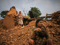 a woman is standing in front of her destroyed house. Kabrepalan Chowk, Nepal. May 6, 2015 (