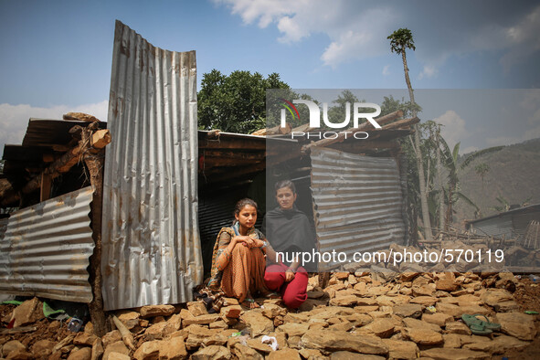 Shikha (left) and Sonu (right) are sitting infront of her destroyed house. Bandevi village, Kabrepalan Chowk, Nepal. May 6, 2015 