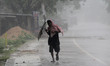 A man boy runs along an embankment ahead of the expected landfall of cyclone Amphan, in Dh...