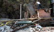 A man remove the rubbles caused by the collapsed houses in the Kobani Village near the Tib...