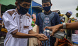 Muslims stand in line to wash their hands with cleaning fluid before carrying out Eid al-F...