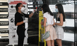 A clerk in a clothing store monitors the temperature for two customers in Milan on May 23,...
