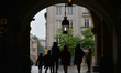 People walk in Krakow's Main Market Square during rainy weather.Rain has returned again t...
