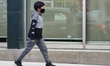 Boy wearing a face mask to protect him from the novel coronavirus (COVID-19) while walking...