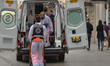 A team of paramedics lifts a patient into an ambulance in Krakow's Main Market Square. Si...