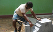 Worker prepares stone during re-construction of the Raja Gopuram tower of the Arul Eswari...