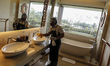 Hotel cleaning service staff wearing face mask, gloves and goggle while disinfecting a roo...