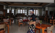 Hotel restaurant staff wearing face mask, gloves and face shield while carrying drinks as...