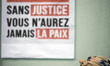 A placard reads 'Justice fro Adama, without justice  you'll never be in peace''. Several o...