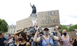 People raise their fists during a rally as part of the 'Black Lives Matter' worldwide prot...