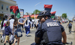 Police officers of the Camden County Police Department keep an eye out as demonstrators ta...