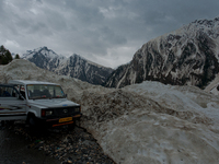 ZOJILA, INDIAN ADMINISTERED KASHMIR, INDIA - MAY 13: A Kashmiri driver parks his vehicle on the snow-cleared Srinagar-Leh highway on a treac...