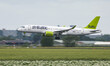 Air Baltic Airbus A220-300 aircraft as seen on final approach flying, landing and touching...