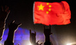 Beijing, China, the 30 April, 2011. Young men wave a chinese flag during a rock festival. 