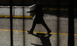 A man walking on the street is seen through the curtain in Brussels, Belgium, July 23, 202...
