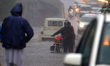 Indian People drives through a flooded road during a Heavy Monsoon Rain shower in Ajmer, R...