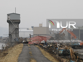 March 21, 2011-Ofunato, Japan-Heavy Equipment clean up factory on debris and mud covered at Tsunami hit Destroyed Industrial Area in Ofunato...