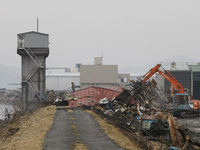 March 21, 2011-Ofunato, Japan-Heavy Equipment clean up factory on debris and mud covered at Tsunami hit Destroyed Industrial Area in Ofunato...