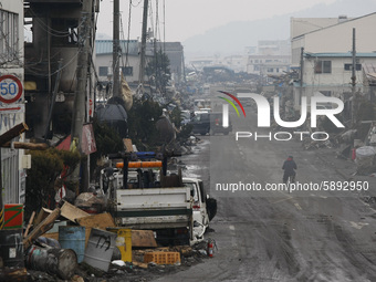 March 21, 2011-Ofunato, Japan-Bike man ride on debris and mud covered at Tsunami hit Destroyed Industrial Area in Ofunato on March 21, 2011,...