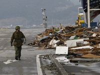 March 21, 2011-Ofunato, Japan-Military Officer check to state on debris and mud covered at Tsunami hit Destroyed Industrial Area in Ofunato...