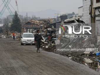 March 21, 2011-Ofunato, Japan-Native Survivor collect scrap iron on debris and mud covered at Tsunami hit Destroyed Industrial Area in Ofuna...