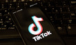 TikTok closeup logo displayed on a phone screen, smartphone and keyboard are seen in this...