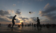 The silhouette of Palestinians at the beach are seen as the sun sets during a summer's day...