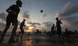 The silhouette of Palestinians at the beach are seen as the sun sets during a summer's day...