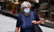 A woman with mask walks through the city during the new Coronavirus disease (COVID-19) aft...