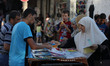Palestinians shop during preparation for the new school year at a market in Gaza City, Pal...