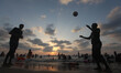 The silhouette of Palestinians at the beach are seen as the sun sets during a summer's day...