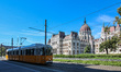 Yellow historical trams going in front of Hungarian Parliament Building are seen in Budape...