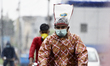 A man wears a plastic protection on his head during rainfall in Kolkata, India, 06 August,...