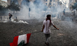 A demonstrator with the Lebanese National Flag take part in a demonstration against the po...