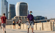 Tourists are seen walking on London Bridge at south bank of Thames river as London encoura...