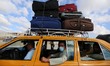 Palestinians sit in a taxi before leaving Rafah border crossing with Egypt, which was reop...