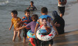 Palestinians are seen at the beach as the sun sets during a summer's day in Gaza City, on...