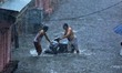 People wade through waterlogged street during the heavy rain in Jaipur, Rajasthan, India,...