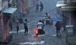 People wade through waterlogged street during the heavy rain in Jaipur, Rajasthan, India,...