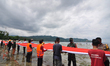 Volunteers are folding the flag of the Republic of Indonesia for 20 meters before spreadin...