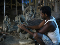 Artisans working on making an idol of elephant headed Hindu god Ganesha at a workshop ahead of the Ganesh Chaturthi festival, in Guwahati, A...