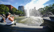A woman takes picture of the fountain at Washing Square Park as New York City continues Ph...