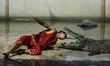 A performer putting his head between the gaping fangs of a crocodile during a show at Samu...