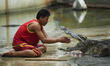 A performer putting his hand between the gaping fangs of a crocodile during a performance...