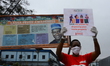 A volunteer holds a placard during a road show calling for a ban of the use of plastic bag...