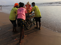 Volunteers carry an idol of the Hindu god Ganesha, onto a cart for its immersion into the Arabian Sea during the Ganesh Chaturthi festival i...