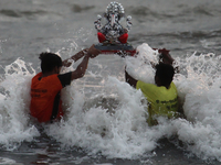 Volunteers immerse an idol of the Hindu god Ganesha, into the Arabian Sea during the Ganesh Chaturthi festival in Mumbai, India on August 26...