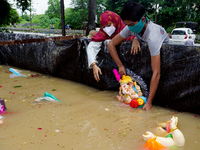 A Hindu devotees immerse idol of elephant-headed Hindu God Ganesh into the artificial pond on the last day of the Ganesh Chaturthi festival...