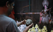 An artist works on a clay idol of the Hindu Goddess ahead of Durga Puja festival in Dhaka,...
